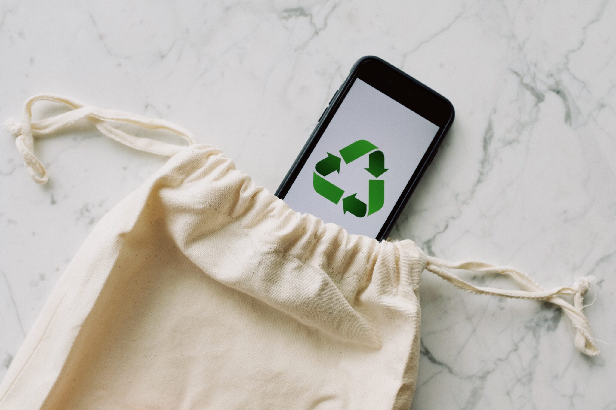 ecobag, com celular saindo dela com símbolo de reciclagem